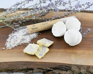 Thrive Bath Company bath salts and bombs, with Donini lemon & lavender white chocolate, on a wood block.
