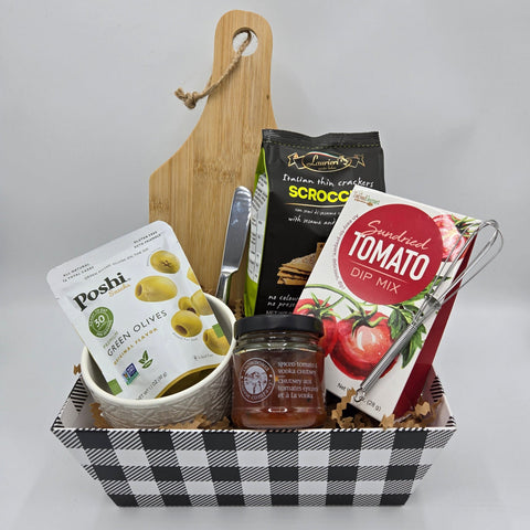 Host with the Most Basket with charcuterie board, dip mix with whisk, ceramic bowl, and savoury treats.