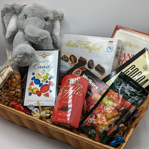 Send a Hug Basket with stuffed animal elephant, treats and chocolates, in a wicker basket.